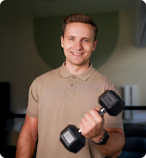 Trener Bartek Malec z hantlą